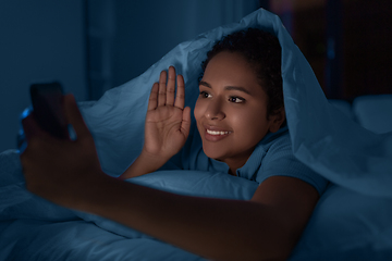 Image showing woman with phone having video call in bed at night