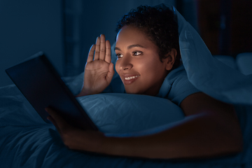 Image showing woman with tablet pc having video call in bed