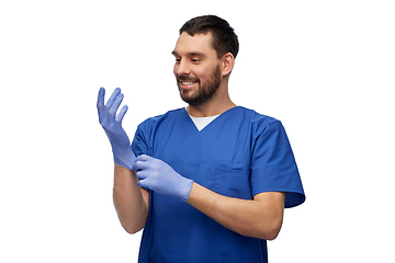 Image showing doctor or male nurse putting medical gloves on