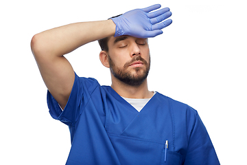 Image showing tired doctor or male nurse in blue uniform