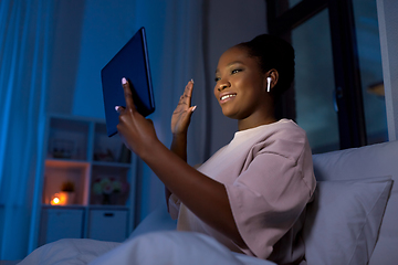 Image showing woman with tablet pc having video call at night