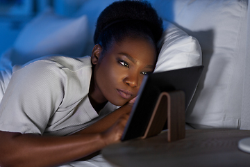 Image showing woman with tablet pc in bed at home at night