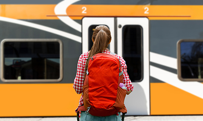 Image showing young woman with backpack traveling over train