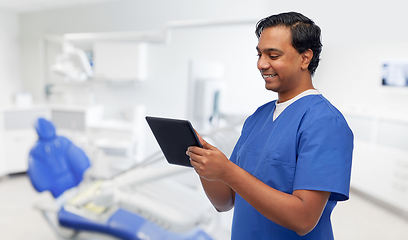 Image showing happy doctor or male dentist using tablet computer