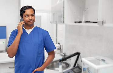 Image showing smiling doctor or male nurse calling on smartphone