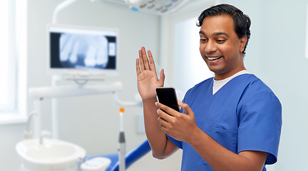 Image showing doctor or male dentist having video call on phone