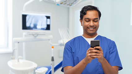 Image showing smiling doctor or male nurse using smartphone