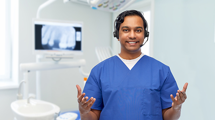 Image showing smiling indian doctor or male nurse with headset