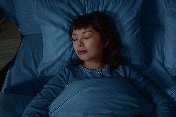 Image showing asian woman sleeping in bed at home at night