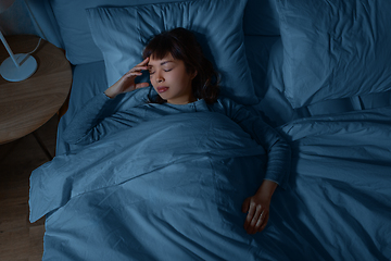 Image showing asian woman sleeping in bed at home at night