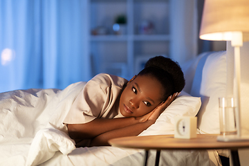 Image showing sleepless african woman lying in bed at night