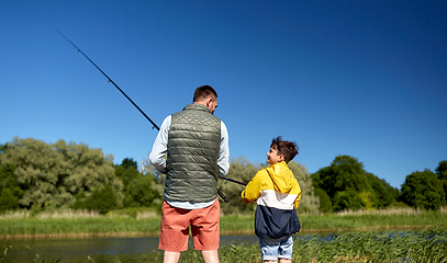 Image showing happy smiling father and son fishing on river