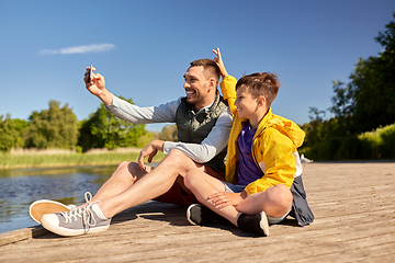 Image showing father and son taking selfie with phone on river