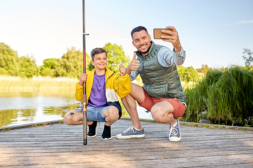 Image showing father and son with fishing rods taking selfie