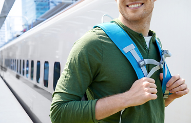 Image showing smiling man with backpack traveling over train