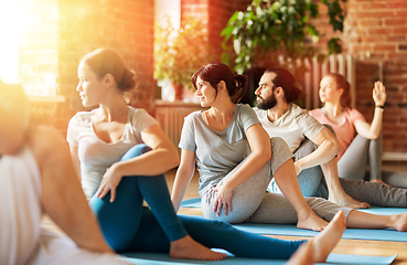 Image showing group of people doing yoga exercises at studio