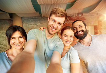 Image showing happy friends at yoga studio or gym taking selfie