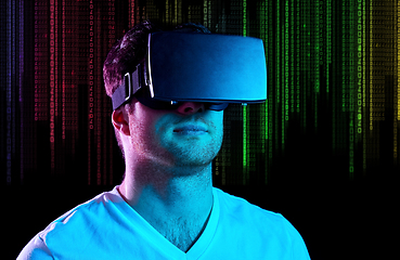 Image showing man in vr glasses in neon lights over binary code