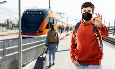 Image showing man in mask with backpack traveling by train