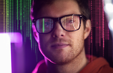 Image showing man in glasses over neon lights and binary code