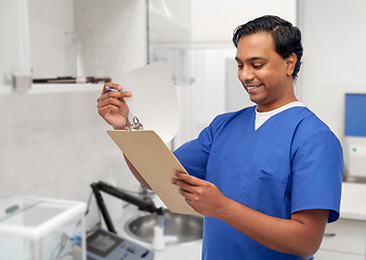 Image showing happy indian male doctor with clipboard