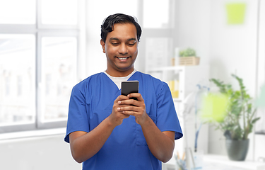 Image showing smiling doctor or male nurse using smartphone