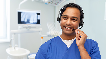 Image showing smiling indian doctor or male nurse with headset