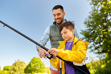 Image showing happy smiling father and son fishing on river