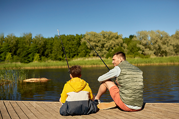 Image showing happy smiling father and son fishing on river