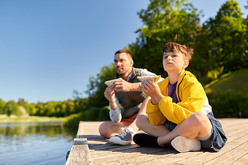 Image showing father and son eating sandwiches on river berth