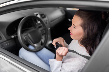 Image showing woman or female car driver fastening seat belt