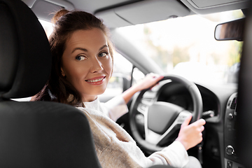 Image showing smiling woman or female driver driving car in city