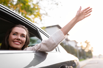 Image showing happy smiling woman or female passenger in car