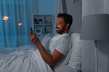 Image showing indian man with tablet pc in bed at home at night