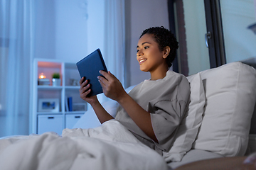 Image showing woman with tablet pc in bed at home at night