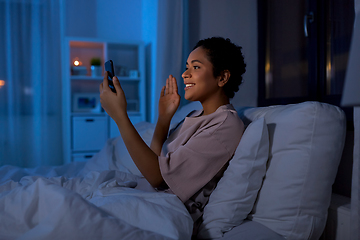 Image showing woman with phone having video call in bed at night