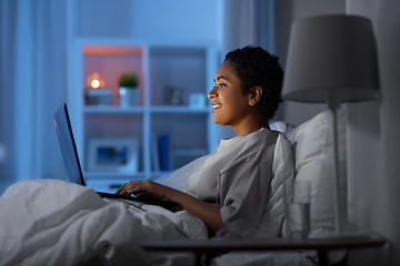 Image showing woman with laptop in bed at home at night