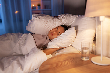 Image showing angry african woman lying in bed and closing ears