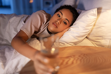 Image showing african american woman drinking water at night