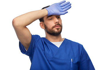 Image showing tired doctor or male nurse in blue uniform