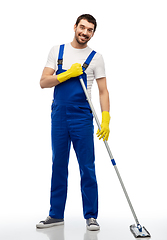 Image showing male cleaner in overal cleaning floor with mop