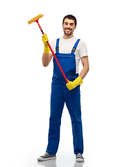 Image showing male cleaner in overal with window cleaning mop