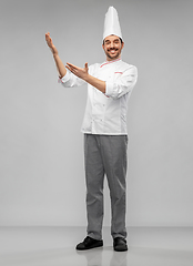 Image showing happy smiling male chef showing something