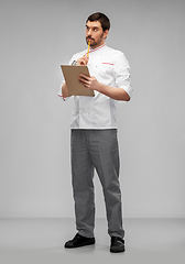 Image showing thinking male chef with clipboard and pencil