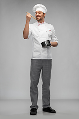 Image showing happy smiling male chef with saucepan tasting food