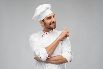 Image showing happy smiling male chef pointing to something