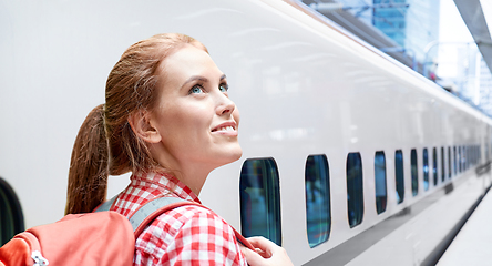 Image showing smiling woman with backpack traveling over train