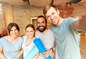 Image showing happy friends at yoga studio or gym taking selfie