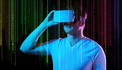 Image showing man in vr glasses over neon lights and binary code