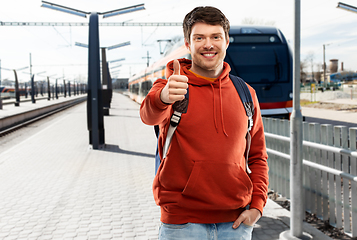 Image showing man traveling by train and showing thumbs up